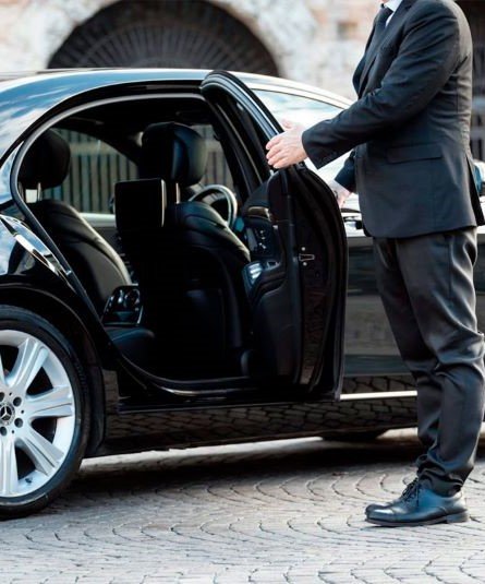 connecticut-limousine-service-elite-transport-service-chauffeur-service-a chauffeur in a suit opening the door of a limousine car